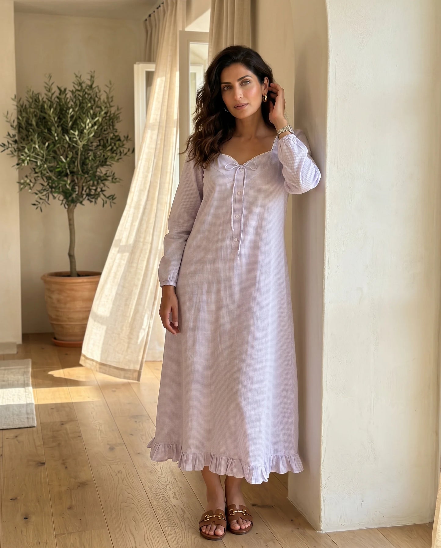 Woman Fluer Lavender Midi Dress Bow Front A Line Skirt standing in a bright room with a plant.