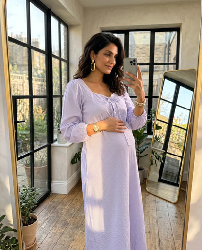 Woman in Fluer Lavender Midi Dress Bow Front A Line Skirt  standing in a room with large windows.