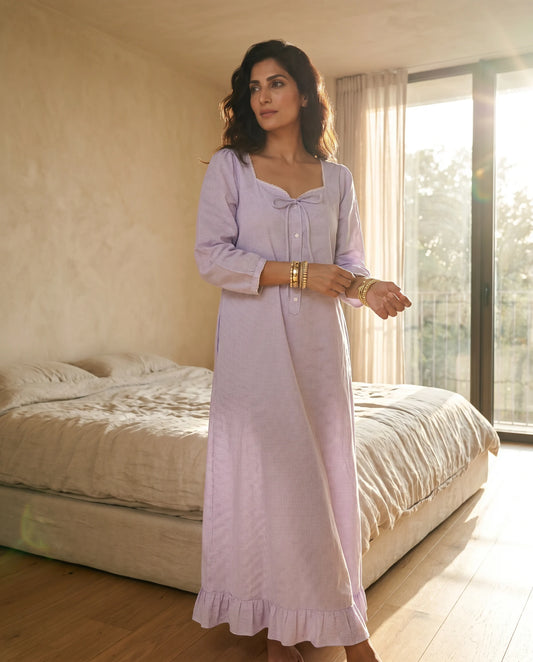 Woman in Fluer Lavender Midi Dress Bow Front A Line Skirt standing in a bedroom.